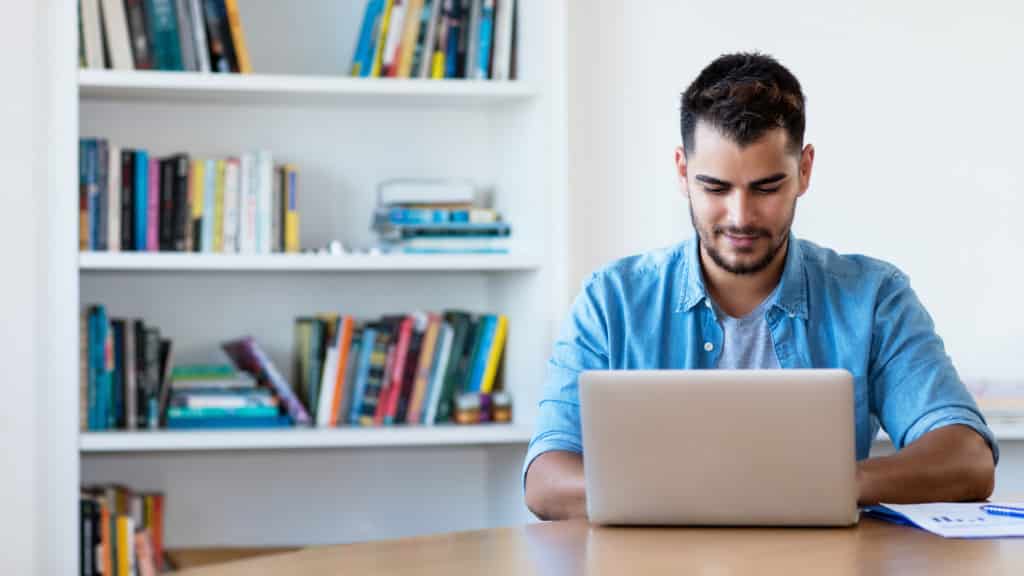 Man in his home reading a therapists blog. Blogs are an important part of marketing for therapists.